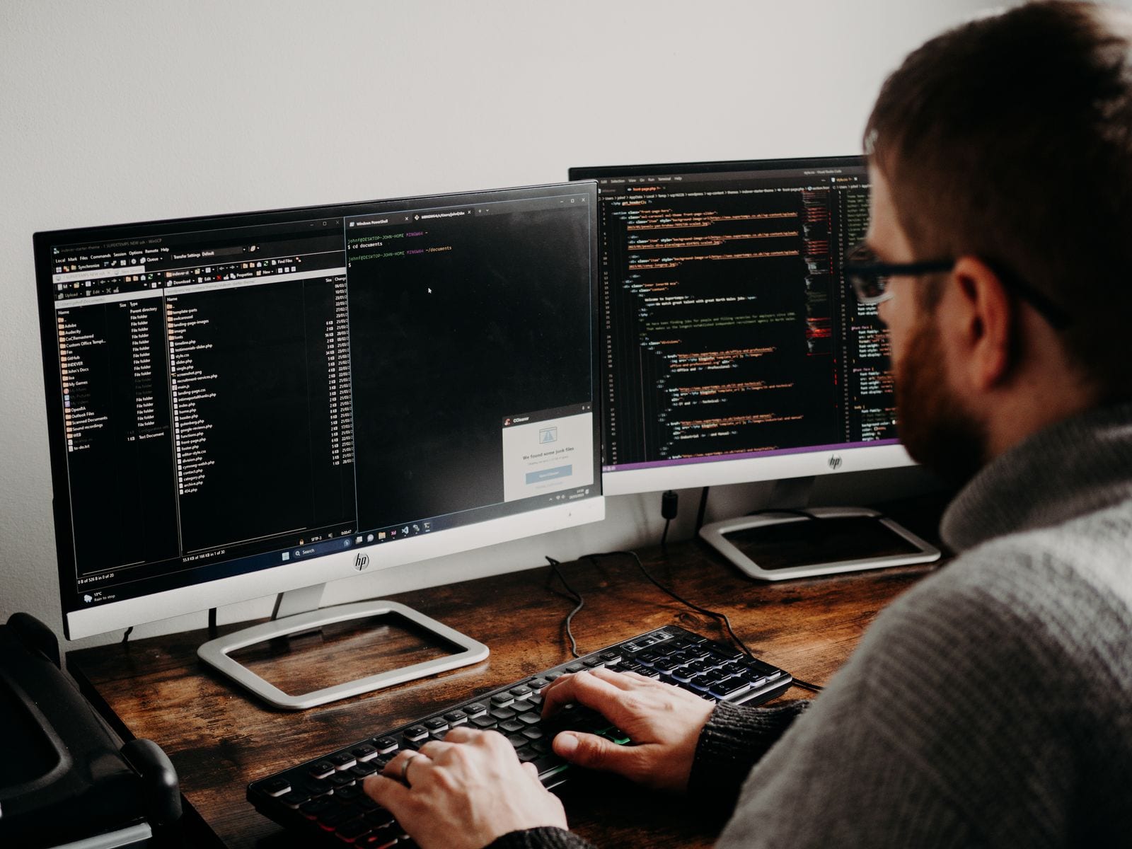 A data engineer working at a laptop with code on screen in a quiet office.